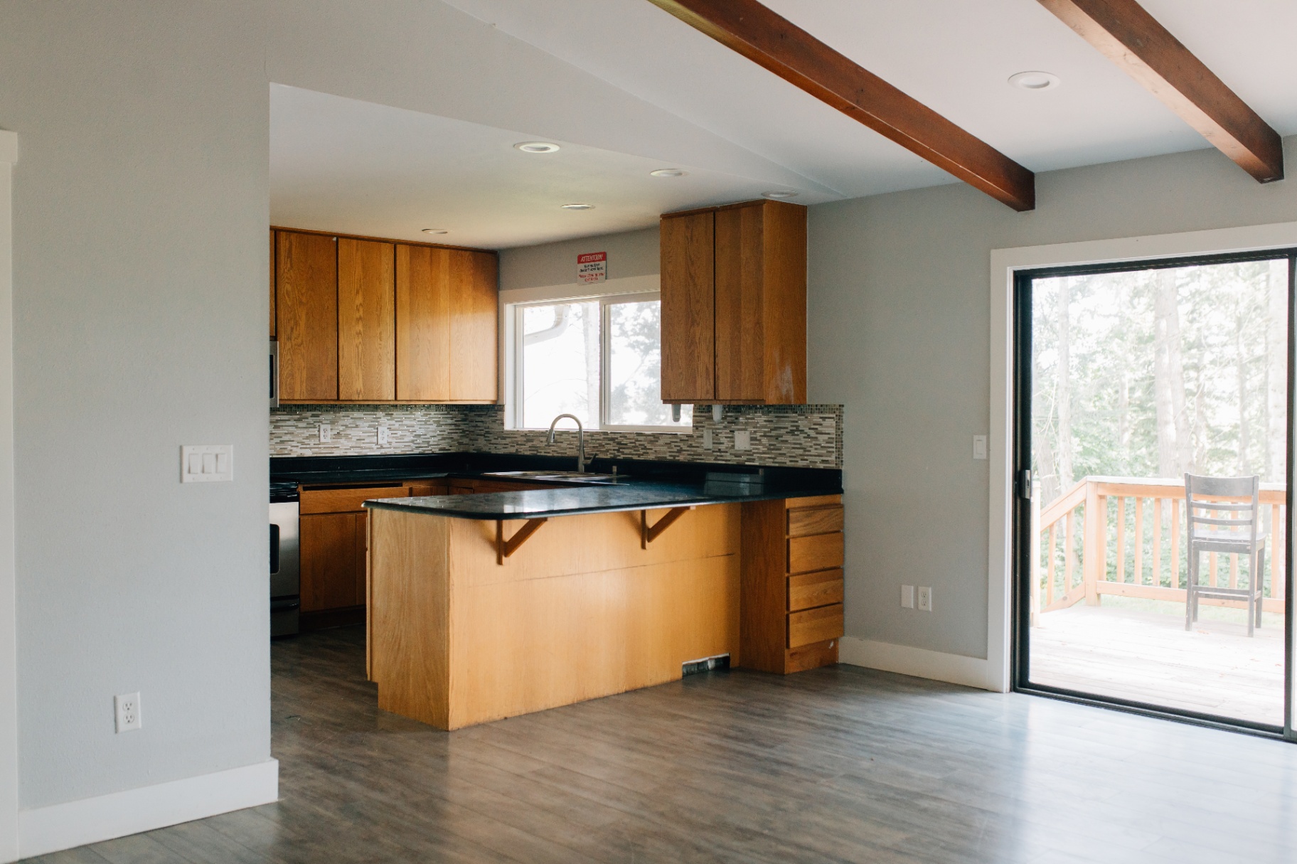 Upstairs kitchen with wood cabinets and a sliding door to the deck